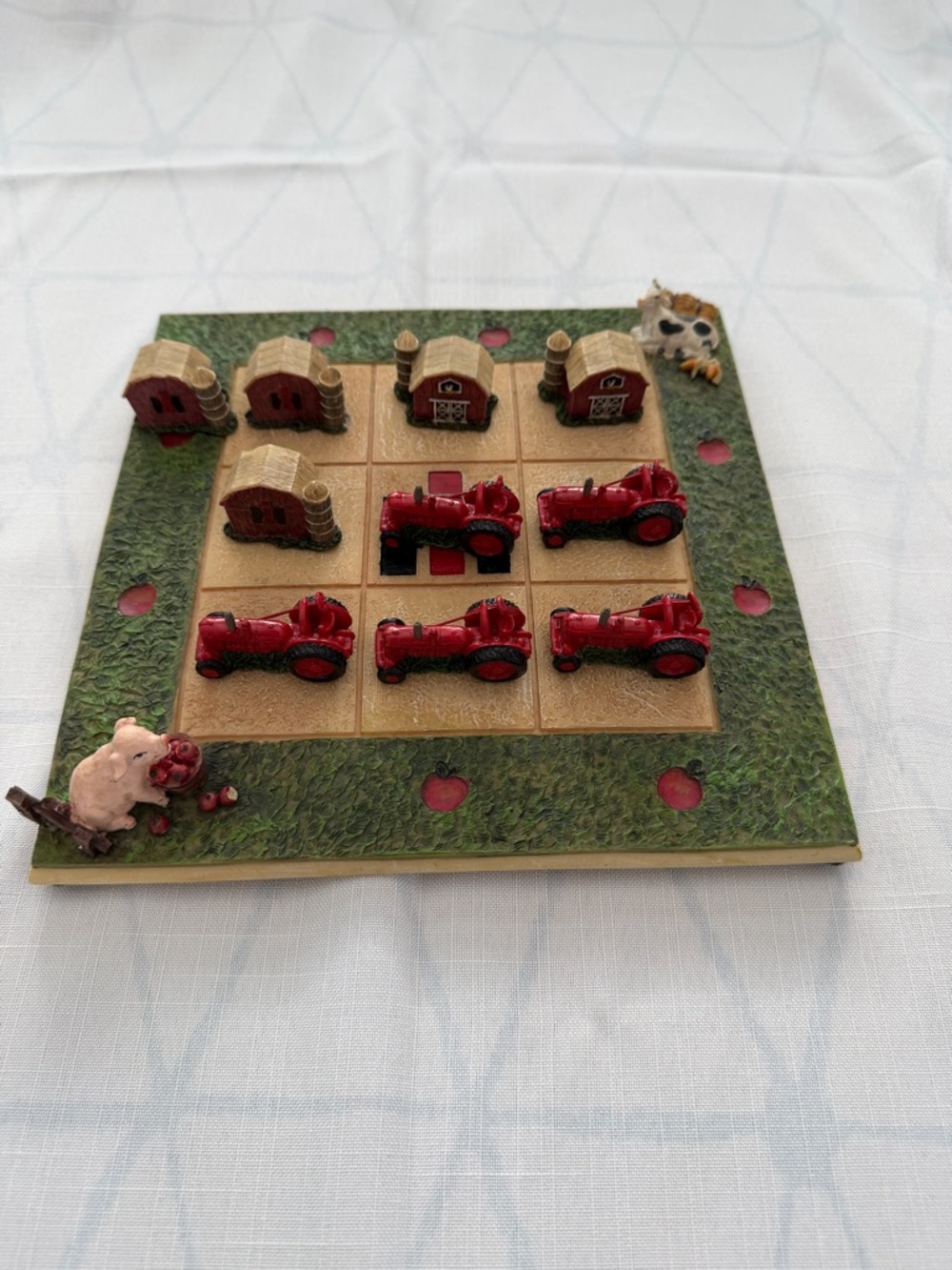 Farm-Themed Tic-Tac-Toe Game Board with Red Tractors and Barnes